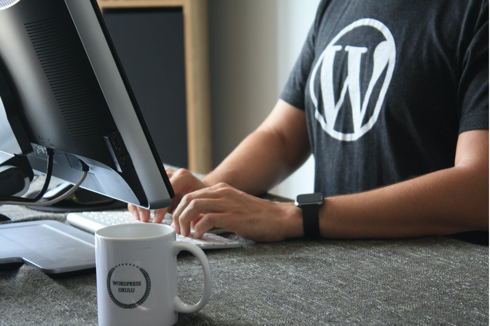 man sitting in front of a computer wearing a wordpress t shirt