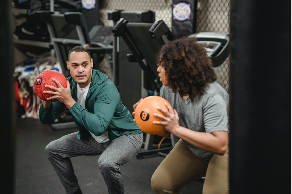 two men exercising with basket balls in their hands